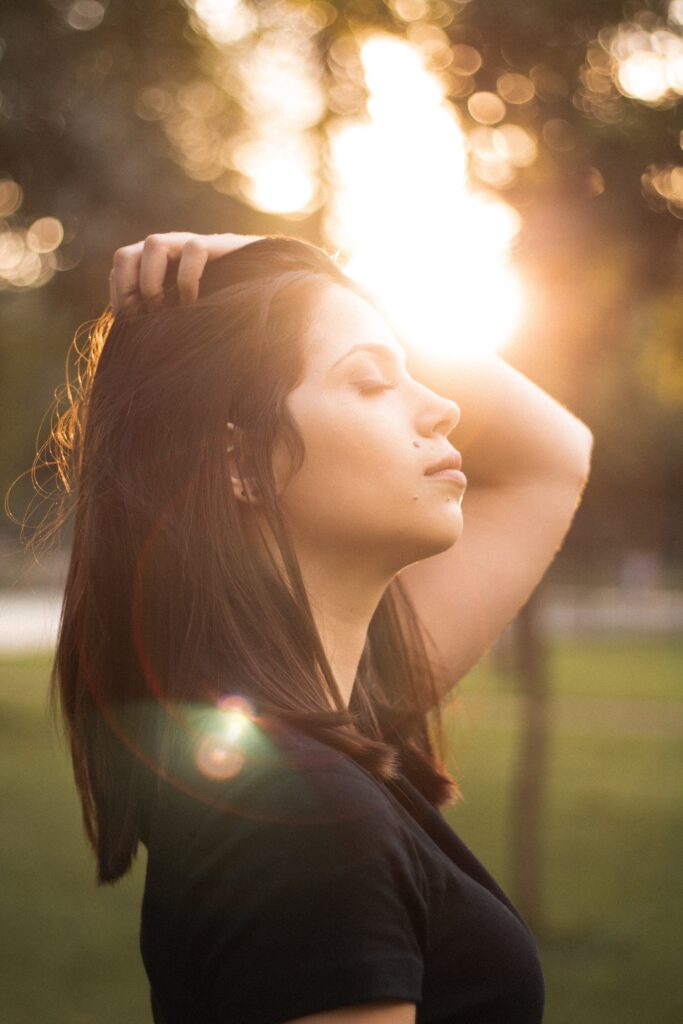 Activités pour diminuer son anxiété : Une femme profite du soleil à l'extérieur